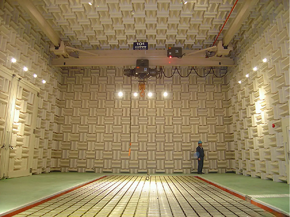 a person standing inside semi anechoic chamber showing a overhead indoor crane