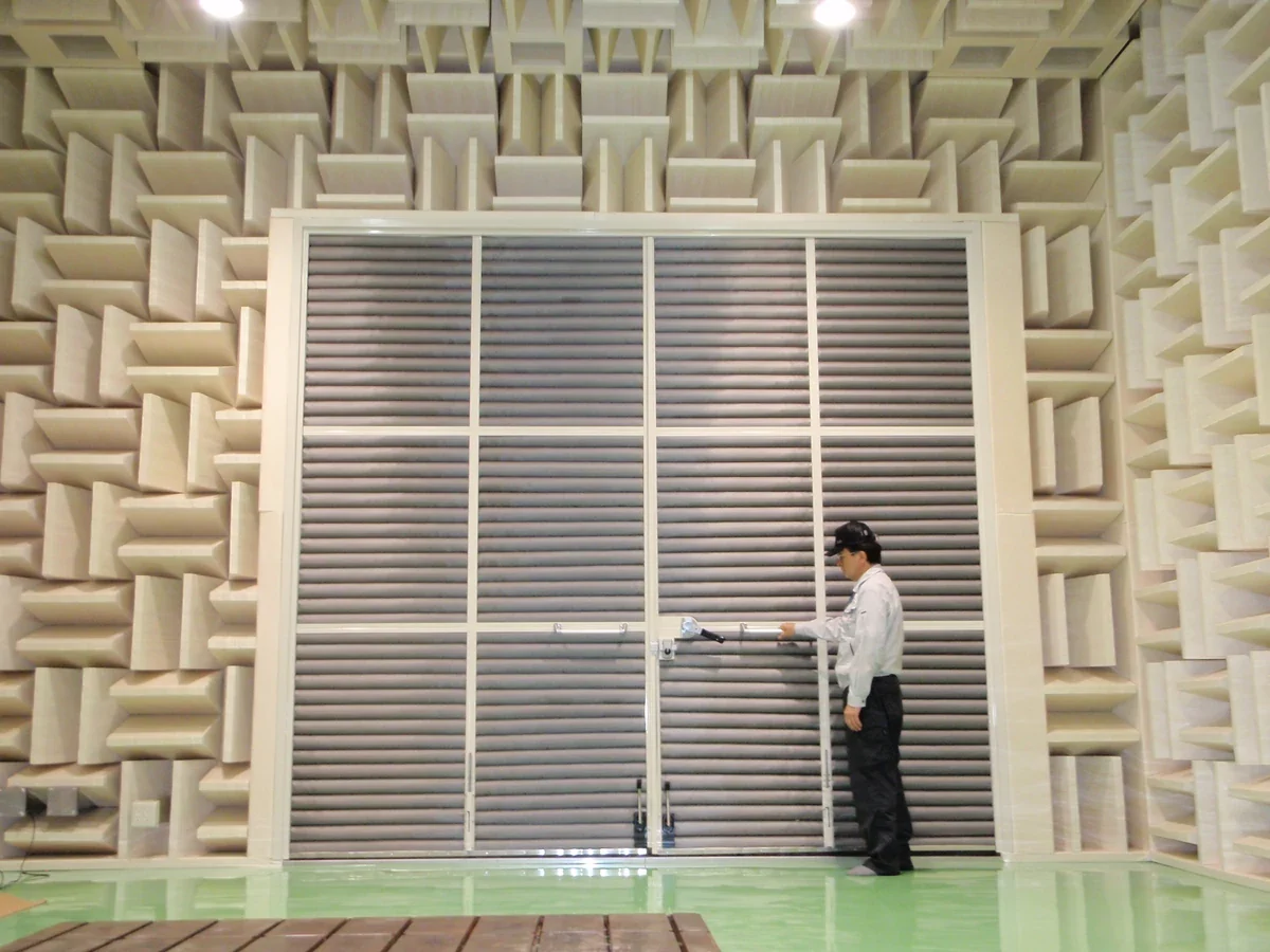 semi anechoic chamber with big door for automobile entry with a person holding door handle